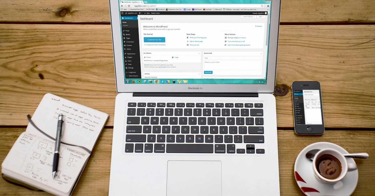 MacBook Air affichant du code sur un bureau en bois avec iPhone, tasse de thé et carnet - Illustration de l'intégration WordPress Claude AI via MCP